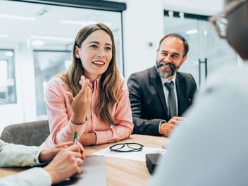 Two people at an office desk discussing business system options