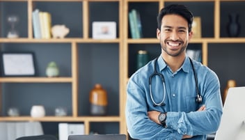 Doctor leaning on desk smiling