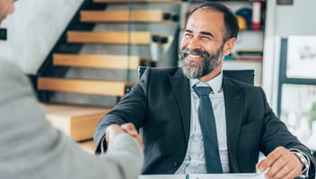 Business man shaking a clients hand and smiling