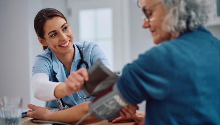 female doctor taking female patient's blood pressure