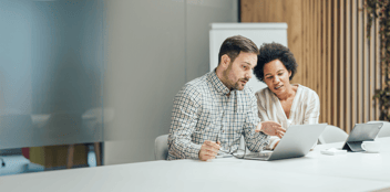 Colleagues in an office environment discussing business systems