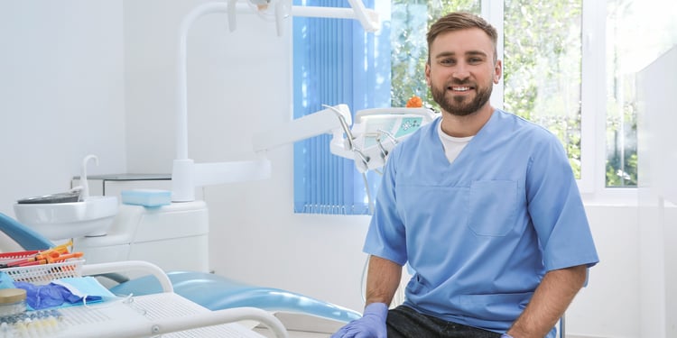 Dentist sitting by a dentist chair and tools