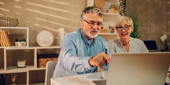 couple looking at laptop screen and pointing 