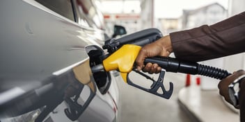 person's hand holding petrol bowser and putting petrol in their car