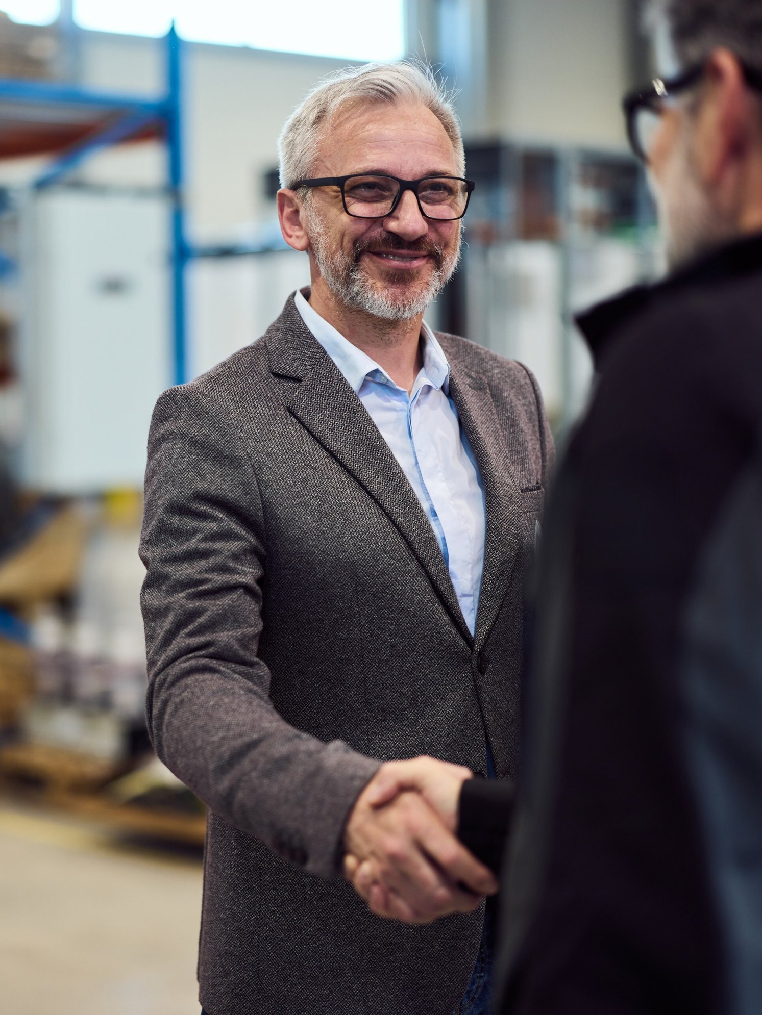 Men shaking hands in warehouse
