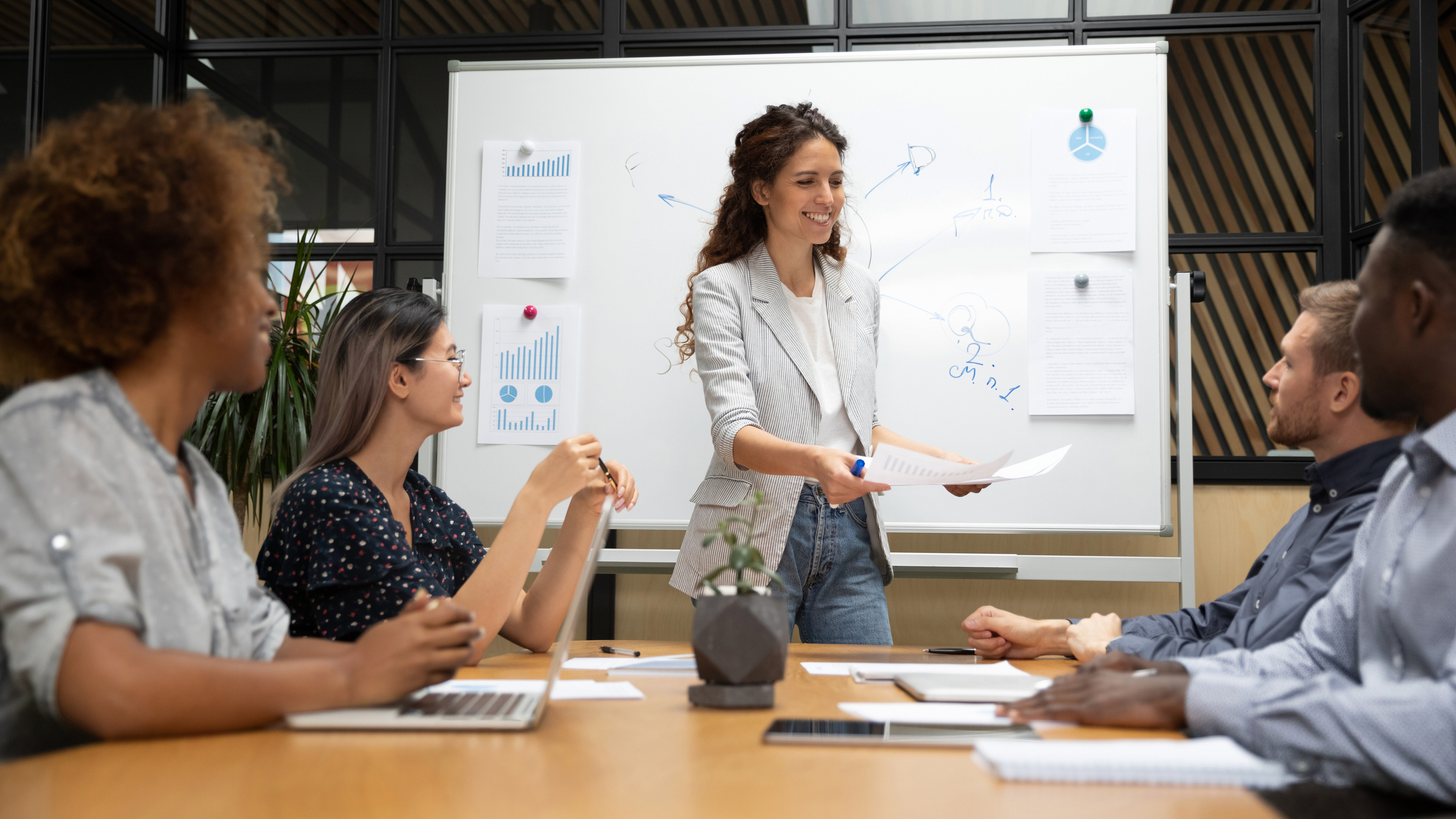 Woman handing out papers to team members